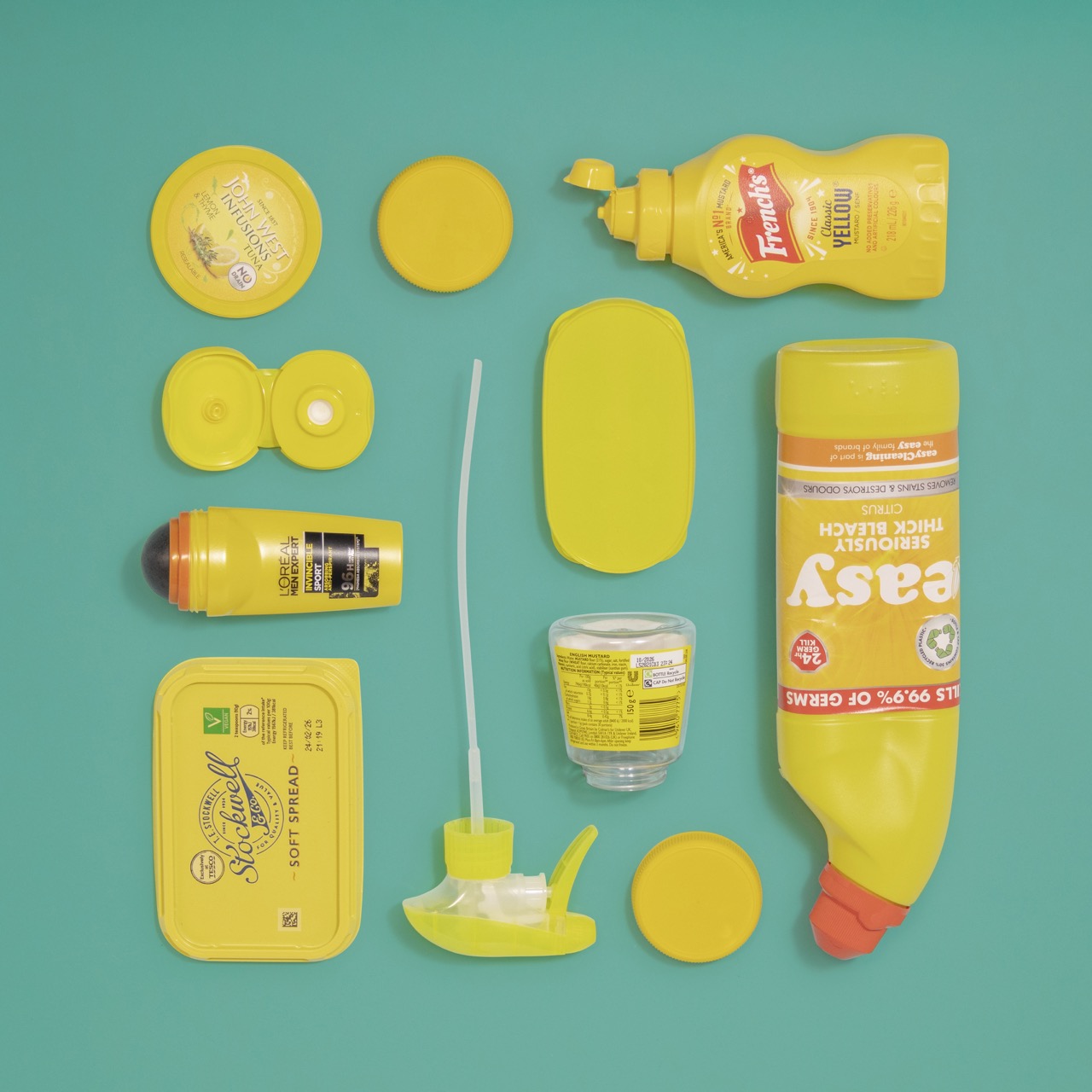 Varied yellow plastic products arranged neatly on a green background
