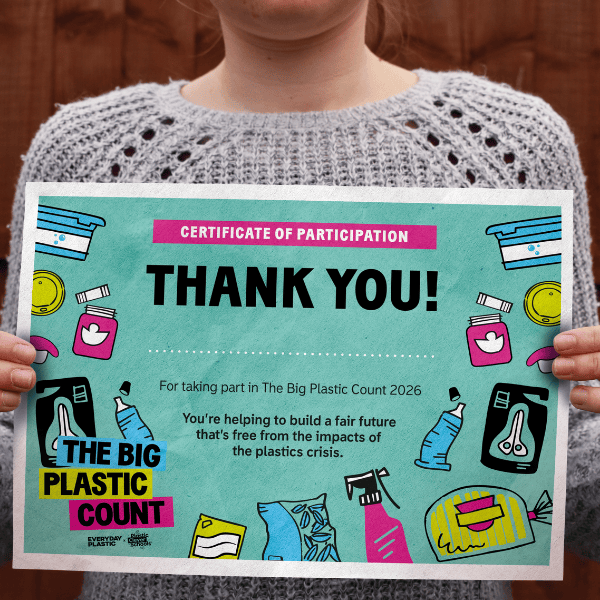 A child holds up a certificate showing that they took part in the The Big Plastic Count